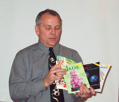 Tony Conway with eyes closed appears to be divining what's in Fred Ward's books